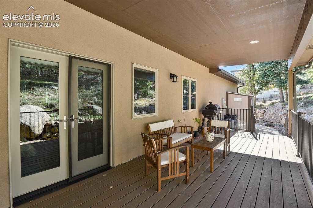 Image 34 of 46: Covered outdoor deck with composite decking, integrated recessed lighting,