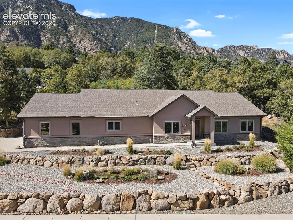 Image 39 of 46: Single-level exterior featuring stone veneer siding, shingled roofing, a co