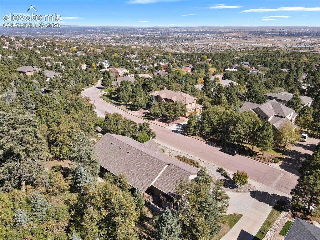 Image 43 of 46: Aerial perspective featuring wooded surroundings, sloping topography, and e