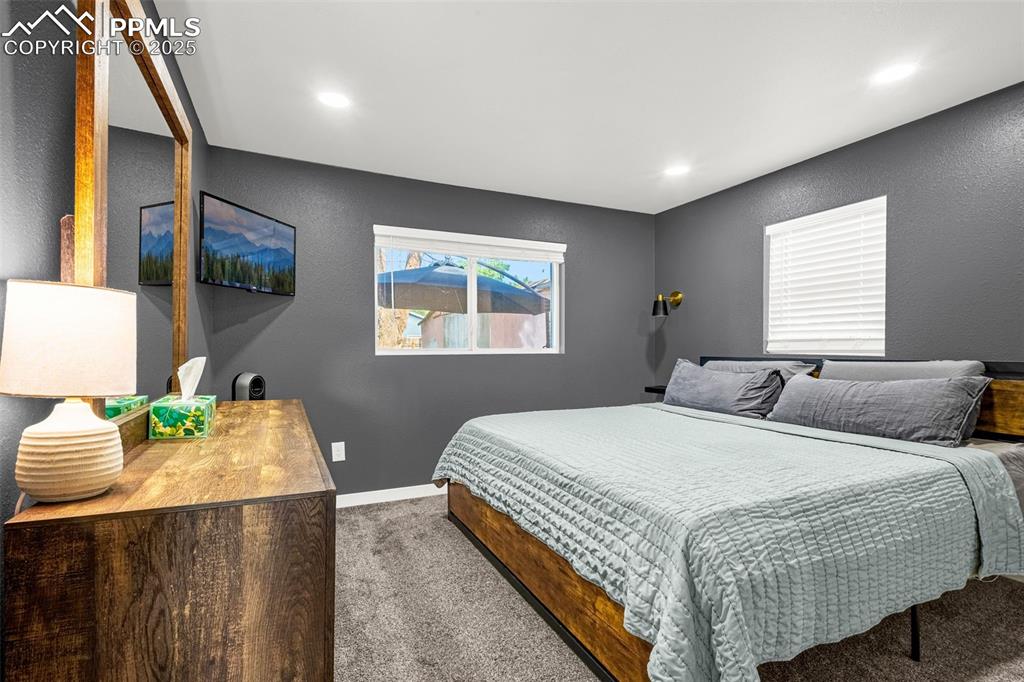 Image 13 of 36: Carpeted bedroom featuring a textured wall, baseboards, and recessed lighti