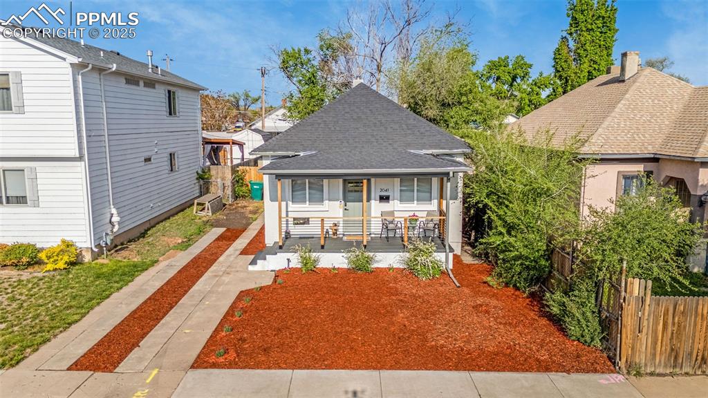 Image 2 of 36: View of front of house with a porch, fence, and a shingled roof