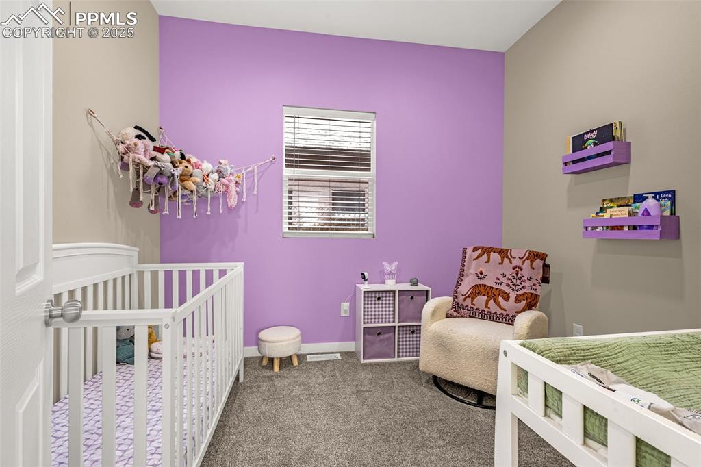 Image 20 of 36: Bedroom featuring carpet, a nursery area, and baseboards