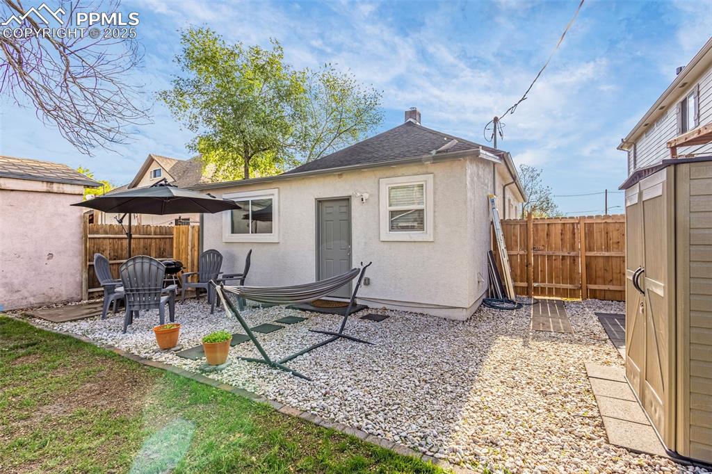 Image 29 of 36: Back of house featuring stucco siding, fence, a patio area, and a chimney