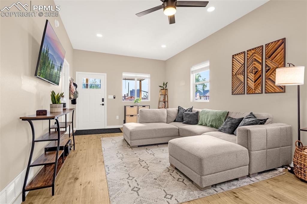 Image 7 of 36: Living area featuring a ceiling fan, recessed lighting, light wood finished