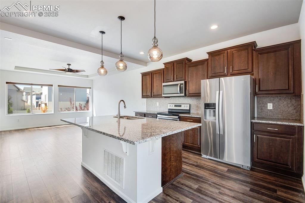 Image 15 of 39: Kitchen featuring stainless steel appliances, light stone counters, a kitch