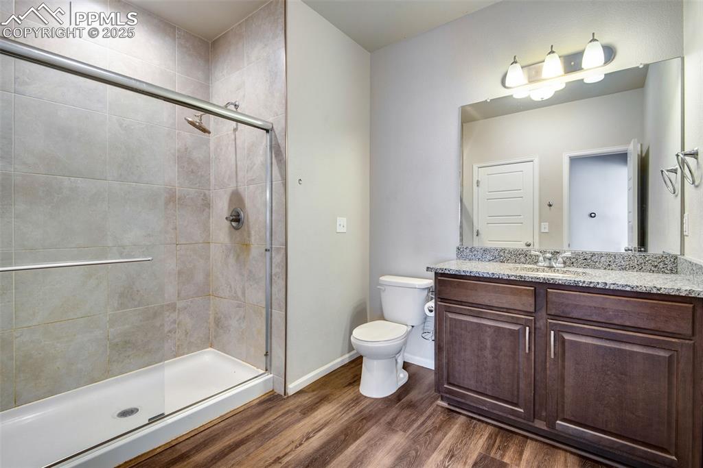 Image 20 of 39: Full bathroom with vanity, dark wood finished floors, and a shower stall