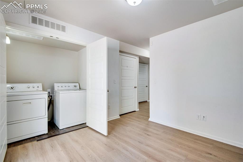 Image 23 of 39: Laundry closet with washer and clothes dryer, with luxury vinyl finished fl