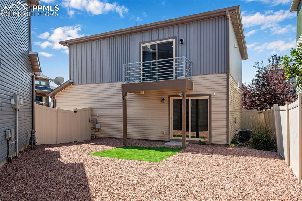 Image 28 of 39: Rear/side view of property with a patio, a fenced backyard, and a balcony