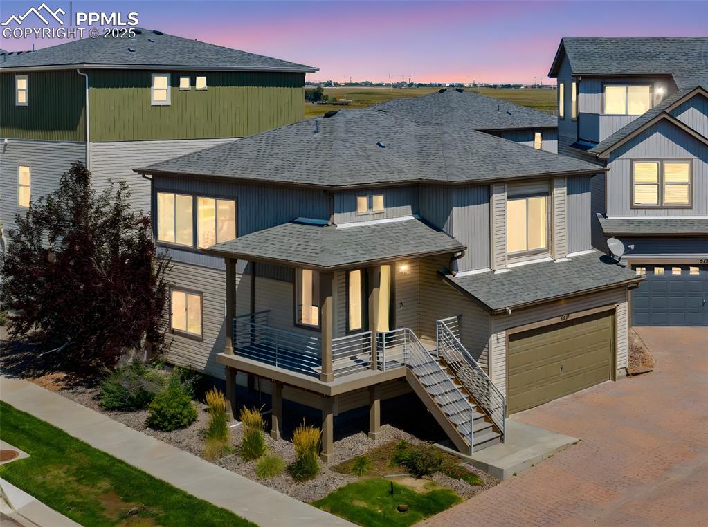 Image 3 of 39: View of front of home with an attached garage, roof with shingles, decorati