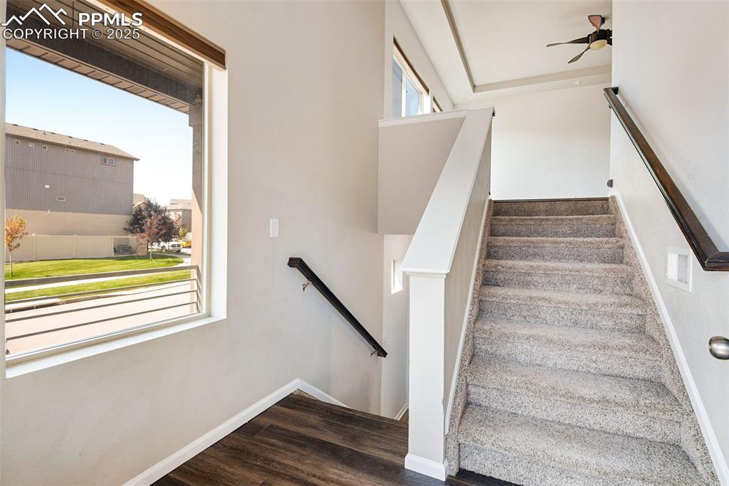 Image 5 of 39: Upper stairway with wood finished floors and carpeted stairs