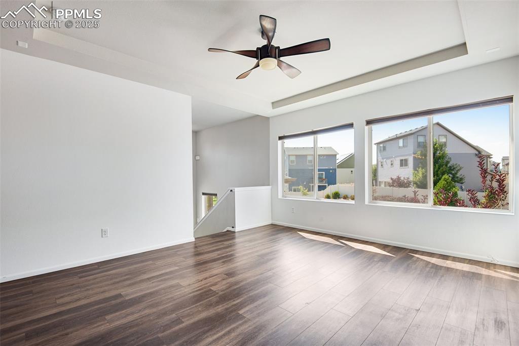 Image 6 of 39: Unfurnished Living room with a raised ceiling, dark wood-type flooring, and