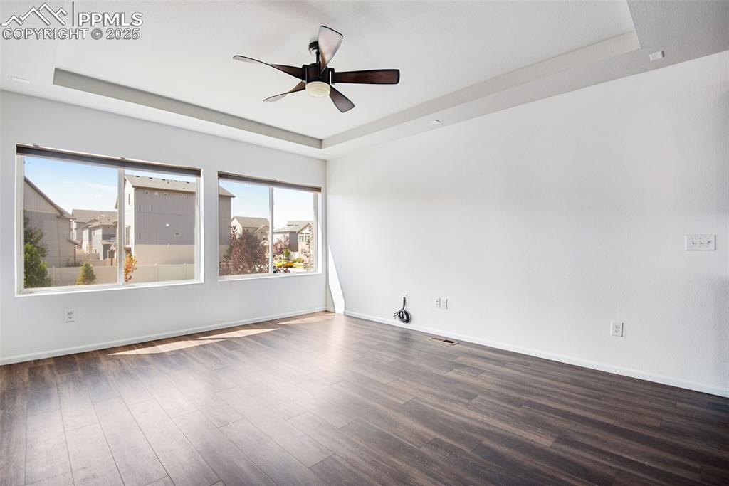 Image 7 of 39: Unfurnished Living room featuring a raised ceiling, dark wood-type flooring