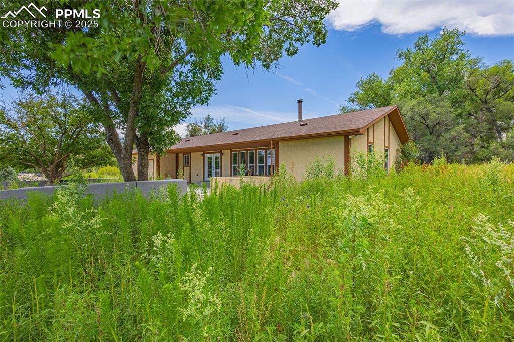 Caption: Back of property with stucco siding and french doors
