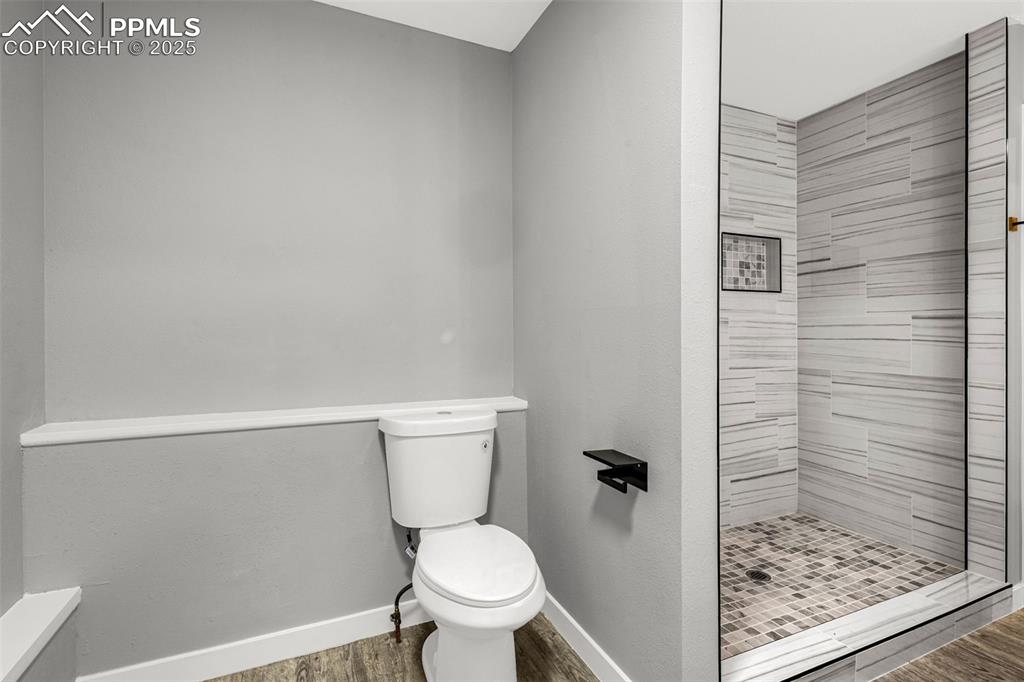 Image 13 of 37: Full bath with a shower stall and wood finished floors