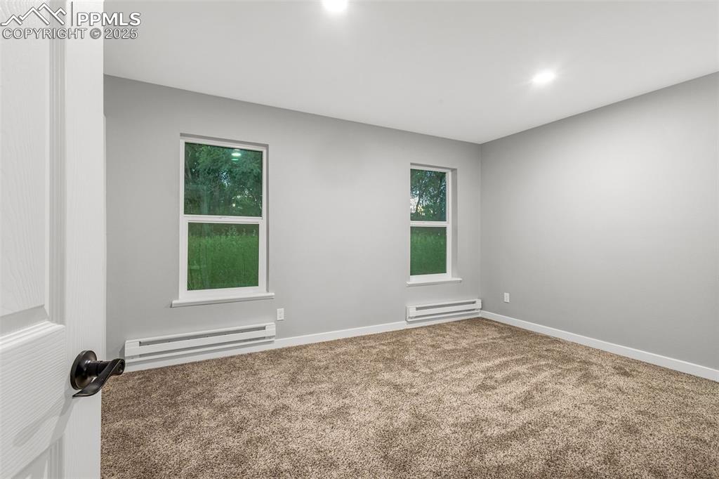 Image 15 of 37: Carpeted spare room with a baseboard heating unit and recessed lighting