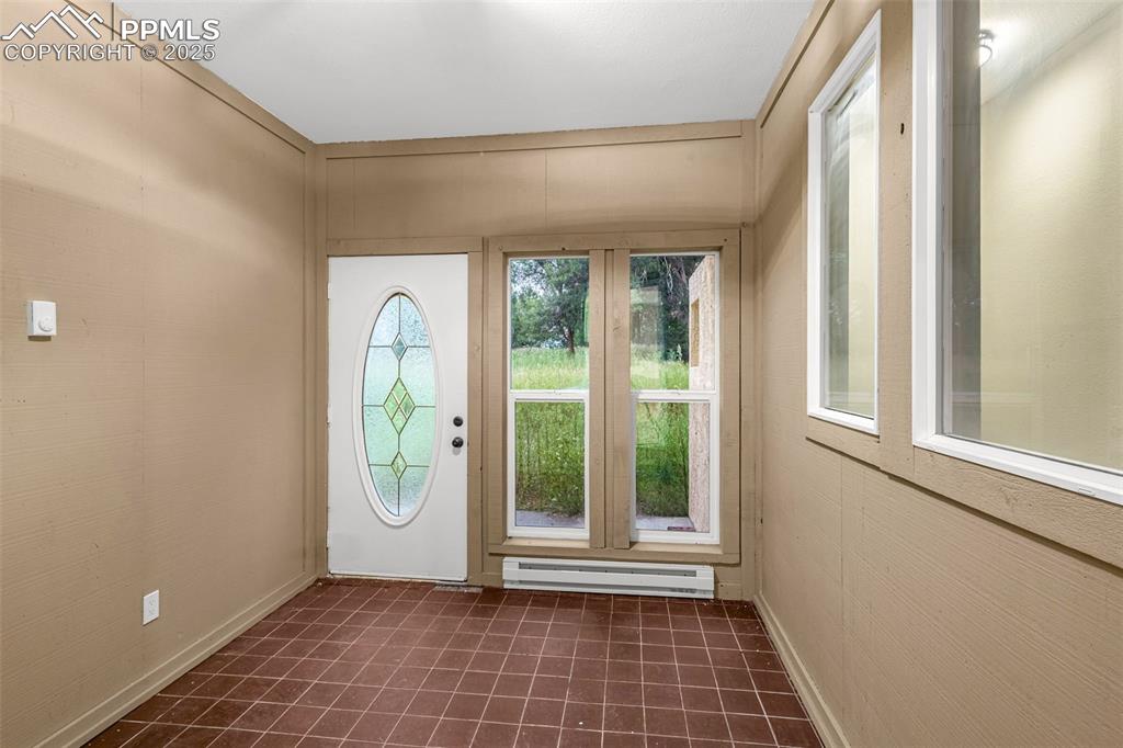 Image 16 of 37: Foyer with a baseboard heating unit and baseboards