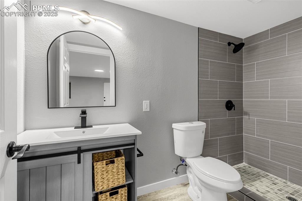 Image 20 of 37: Full bath with tiled shower and vanity