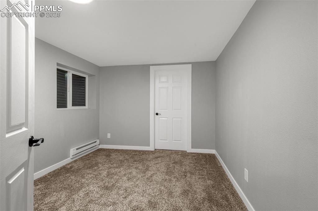 Image 21 of 37: Unfurnished room with a baseboard heating unit and carpet floors