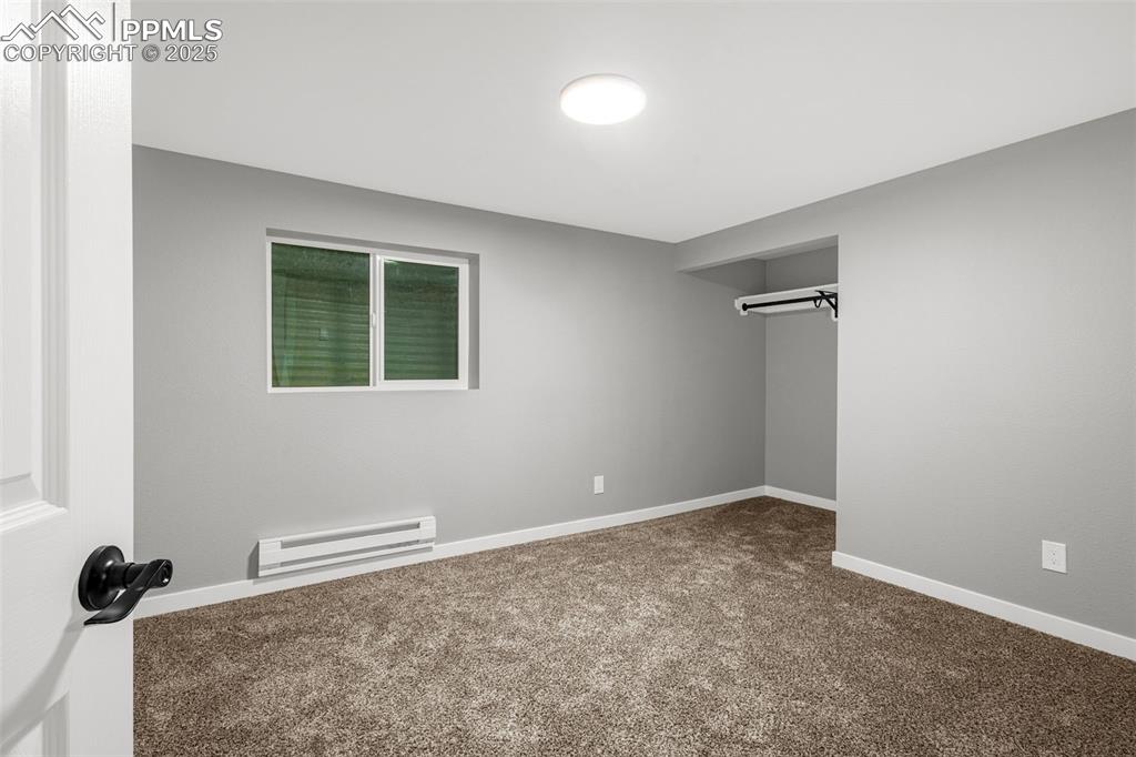 Image 22 of 37: Unfurnished bedroom with a baseboard radiator and carpet floors