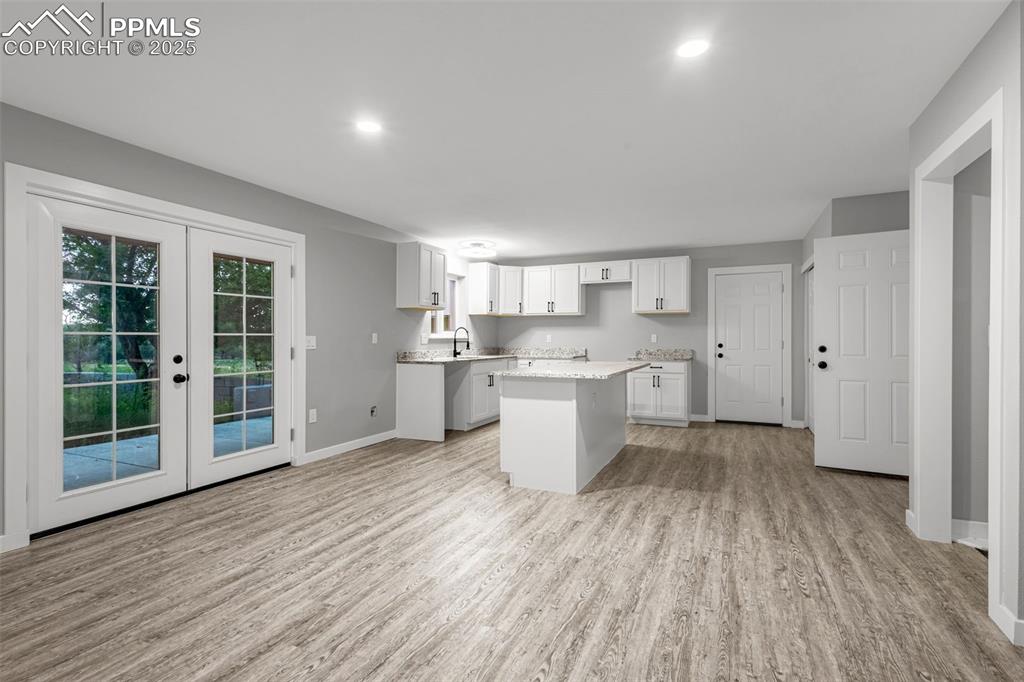 Image 3 of 37: Kitchen featuring light wood finished floors, a kitchen island, french door