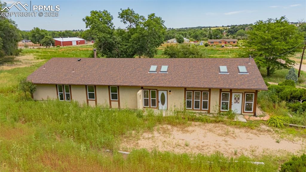 Image 32 of 37: View of front of property featuring stucco siding and roof with shingles