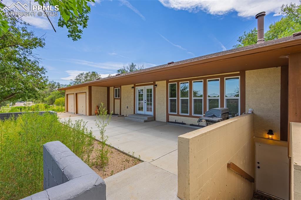 Image 36 of 37: Back of house featuring stucco siding, a garage, concrete driveway, and fre