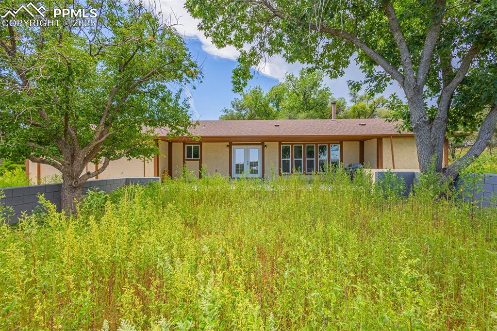 Image 37 of 37: Rear view of house featuring stucco siding, french doors, and an attached g
