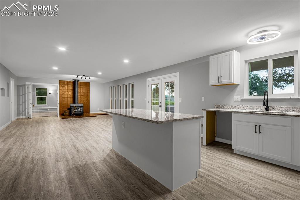 Image 6 of 37: Kitchen featuring a wood stove, light wood-style floors, recessed lighting,