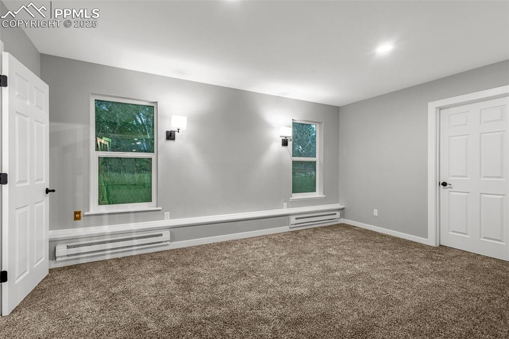 Image 8 of 37: Carpeted empty room featuring a baseboard heating unit