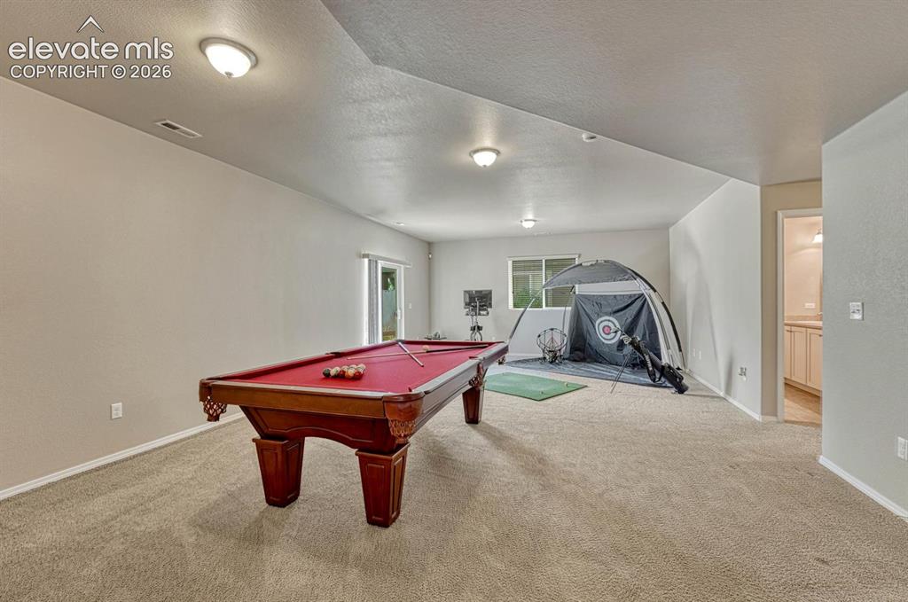 Image 10 of 50: Finished walk out family/rec room with gym and gaming areas.