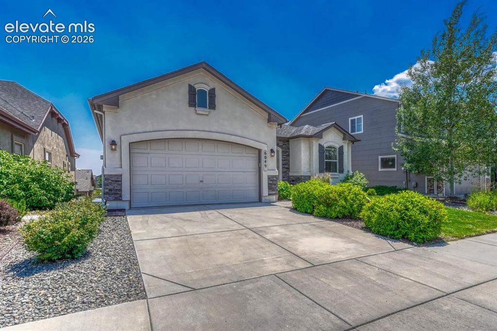 Image 12 of 50: Low maintenance landscaping with rock gardens, grass, and mature trees and