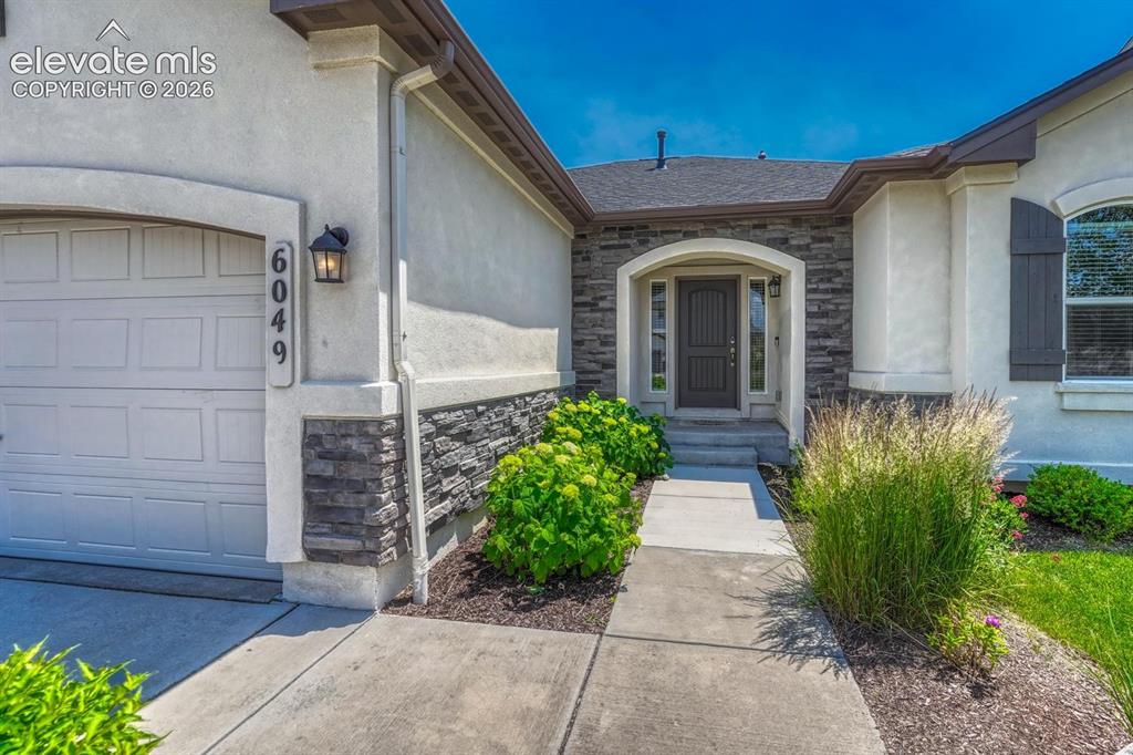 Image 13 of 50: Attractive front walkway with stone accents and arched front entry.