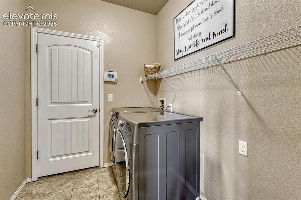 Image 25 of 50: The Laundry Room has garage access and features tile flooring, a built in s