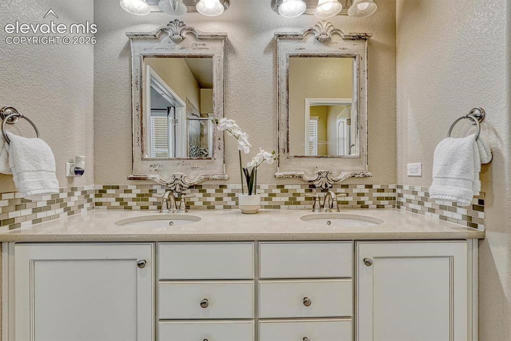 Image 29 of 50: The Primary Bathroom features a beautiful dual sink quartz vanity with tile