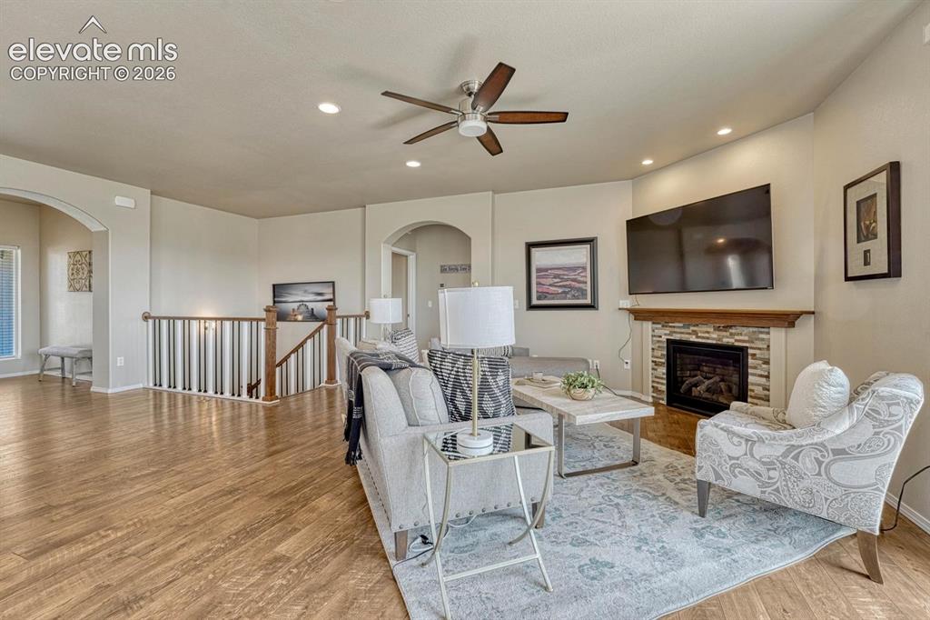 Image 3 of 50: The Living Room features LVP flooring, a lighted ceiling fan, and gas firep