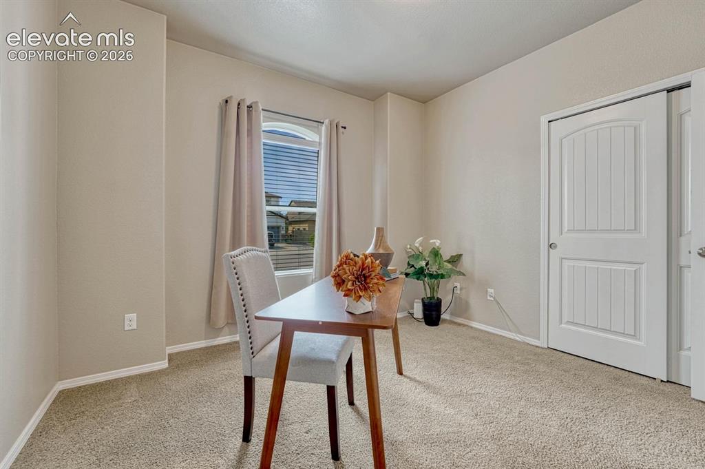 Image 31 of 50: Bedroom #2 (currently an office) with neutral carpet, front yard views, and