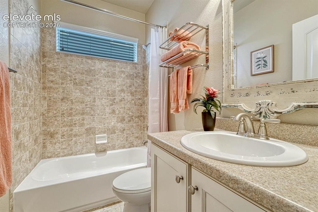 Image 33 of 50: Main Level Full Bathroom with vanity, mirror, and tiled tub/shower.