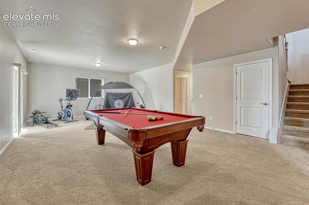 Image 34 of 50: Finished walk out basement with gaming and gym areas.