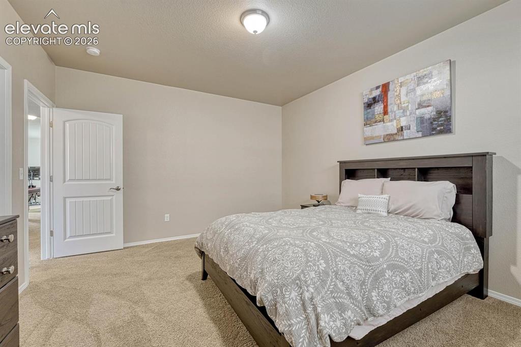 Image 40 of 50: Basement Bedroom #4 has neutral carpet.