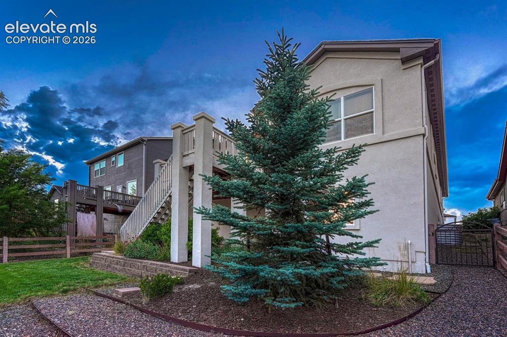 Image 45 of 50: Nicely manicured yard with auto sprinklers, rock walkways, and beautiful tr