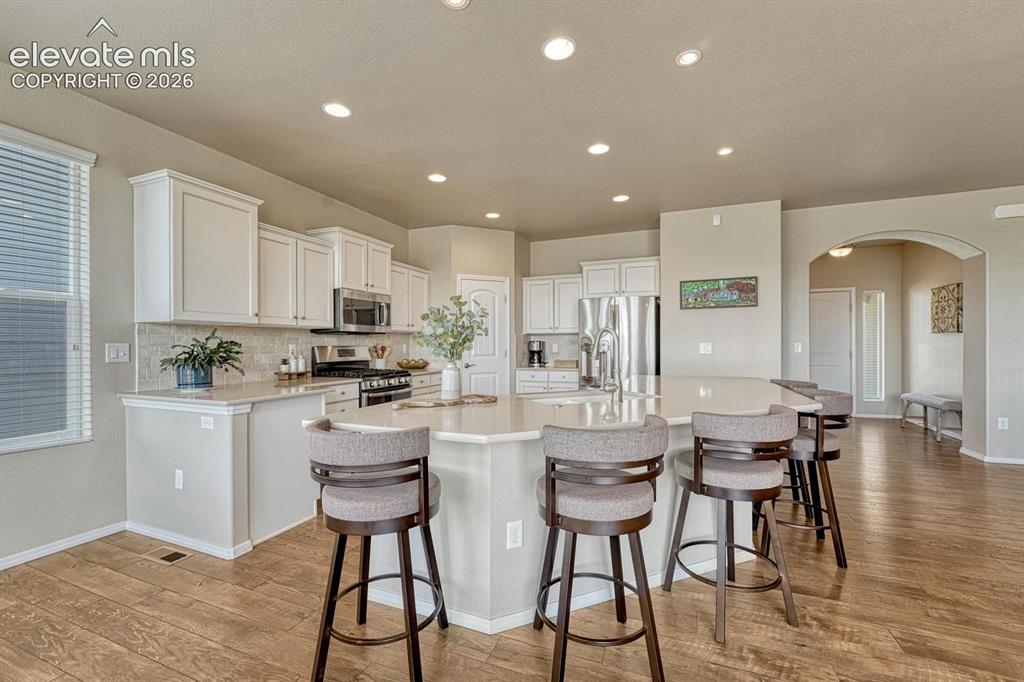 Image 5 of 50: Gourmet Island Kitchen with pantry, white cabinetry with quartz countertops