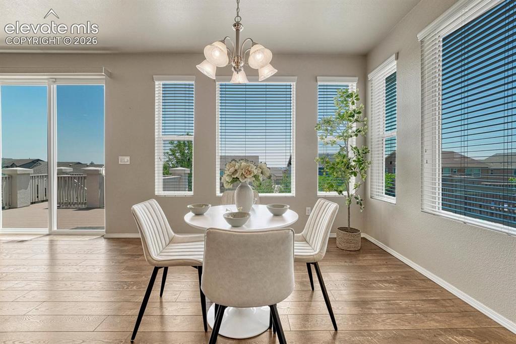 Image 6 of 50: Dining Area with light fixture and wall of windows that bring in lots of na