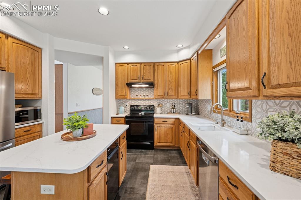 Image 15 of 39: Kitchen featuring decorative backsplash, recessed lighting, appliances with