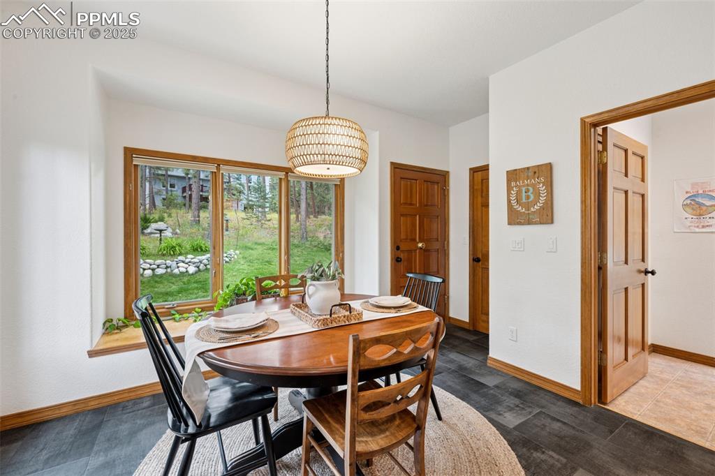 Image 16 of 39: In-Kitchen dining area featuring grand windows, and Black Slate style tile