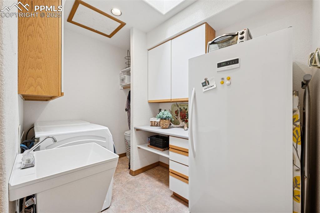 Image 18 of 39: Washroom featuring cabinet space, recessed lighting, sink and a skylight