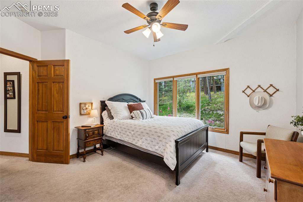 Image 27 of 39: Bedroom with light colored carpet and a ceiling fan