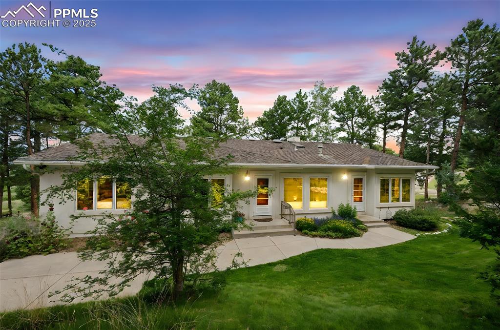 Image 3 of 39: View of front of home with stucco siding, a front lawn, and roof with shing