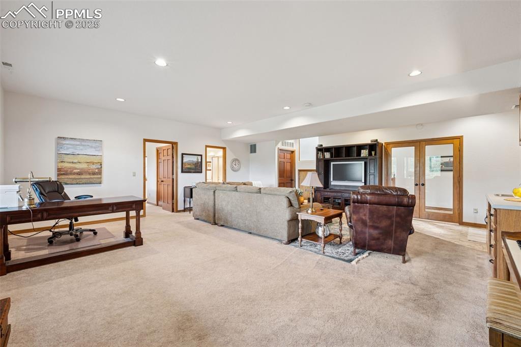 Image 31 of 39: Living room featuring a desk, recessed lighting, light carpet, and french d