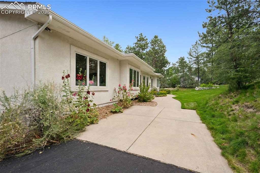 Image 37 of 39: View of side of home with a patio, stucco siding, and a lawn
