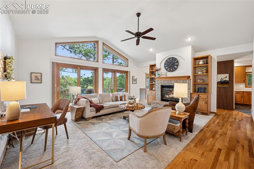 Image 6 of 39: Living room featuring light wood finished floors, a brick fireplace, ceilin